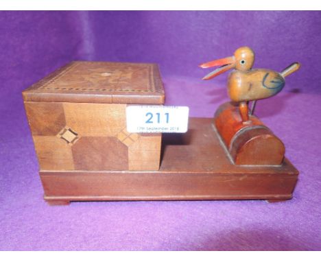 A vintage smokers humidor and cigarette dispenser with mechanical bird figure