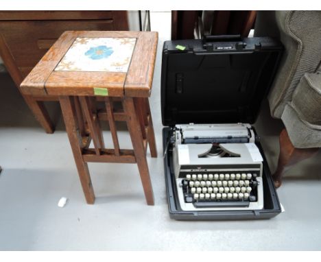 An early 20th Century oak frame tiled top plant stand and an Adler Gabrielle 25 typewriter