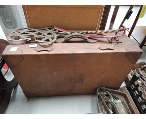 A vintage leather suitcase and carpet beater