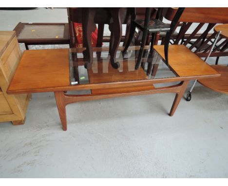 A vintage teak and glass coffee table