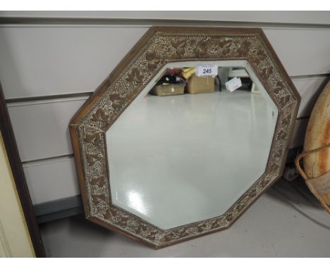 A vintage hexagonal mirror with arts and crafts style frame