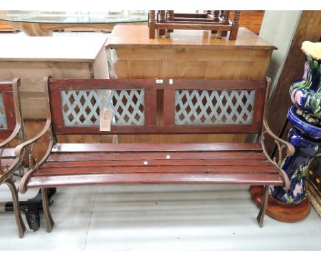 A vintage garden bench having cast ends, slat seat and woven type inset back (1 of 2 lots)