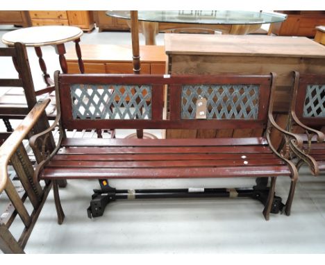 A vintage garden bench having cast ends, slat seat and woven type inset back (1 of 2 lots)