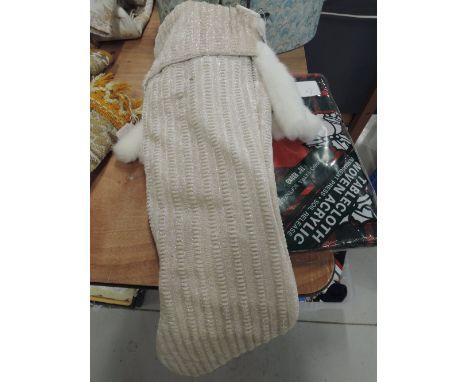 A selection of Christmas items with tags attached, this includes a tartan table cloth, a card holder, and a stocking.