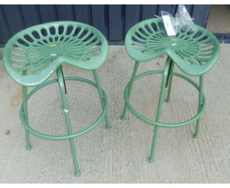 A pair of green painted metal stools in the form of tractor seats*