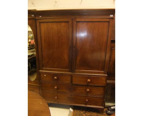 A Victorian mahogany linen press with two cupboard doors enclosing two linen shelves over two short and two long drawers on b