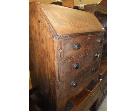 A 19th Century oak three drawer bureau on bracket feet
