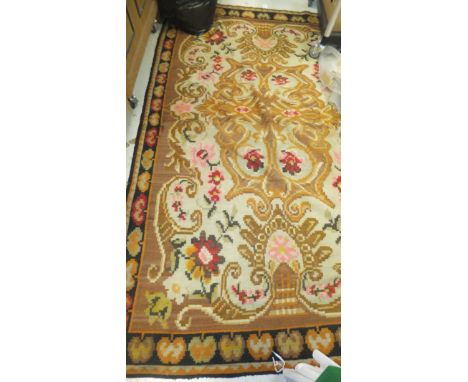 A Kelim carpet decorated with floral motifs in red, orange, yellow, pink and green, on a beige and cinnamon ground, within a 