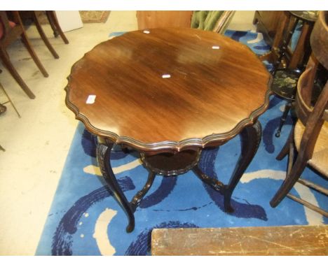 An Edwardian mahogany occasional table, the cabriole legs with leaf carved decoration united by a central shelf