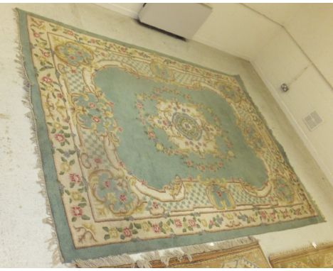 A Persian style carpet, the central medallion in cream, pale blue, mushroom and green on a pale green ground within floral de