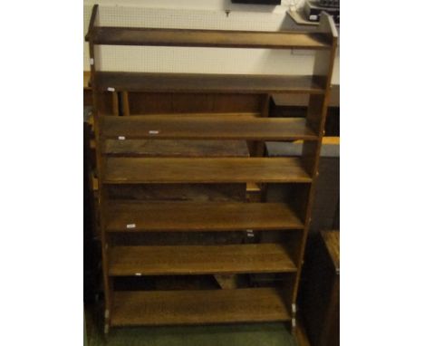 An oak open bookcase with seven shelves, in the Arts and Crafts manner CONDITION REPORTS Has three pegs missing.  Appears to 