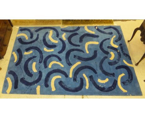 A modern machine woven wool carpet with blue and white scroll decoration on a blue ground, 303 cm x 195 cm