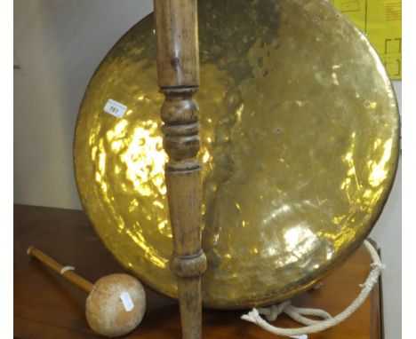 A large brass gong with wood and leather beater, together with a cream painted candlestick style table lamp