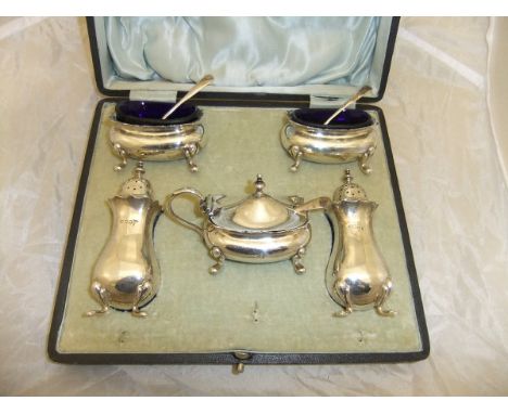 A George V silver cased cruet comprising lidded mustard, a pair of open salts and a pair of peppers in the Georgian taste (by