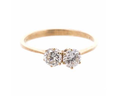 A DIAMOND RING centred with two claw-set round brilliant-cut diamonds weighing approximately 0.72cts in total, impressed 750,