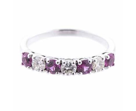 A RUBY AND DIAMOND HALF-ETERNITY RING claw-set to the centre with four circular mixed-cut rubies weighing approximately 0.64c