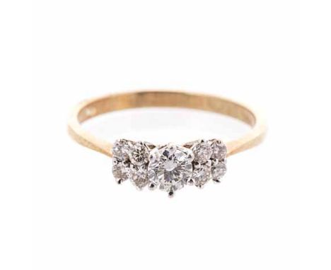 A DIAMOND RING centred with a claw-set round brilliant-cut diamond weighing approximately 0.20cts, flanked on either side by 