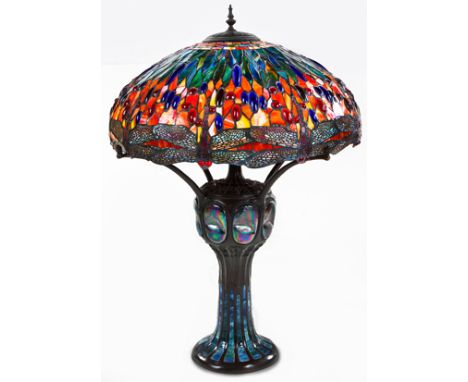 A THREE-LIGHT TIFFANY STYLE TABLE LAMP, 20TH CENTURY with a colourful shade supported on four supports terminating in a bulbo