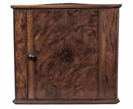 A FLAME MAHOGANY APPRENTICE CORNER CUPBOARD, 19TH CENTURY the triangular top above a door enclosing a shelf, on a conforming 