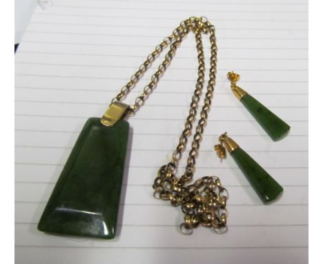 A gold chain with jade style pendant and a pair of earrings
