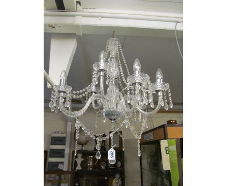 A nine branch chandelier with glass stems and hung with lustre chains and drops