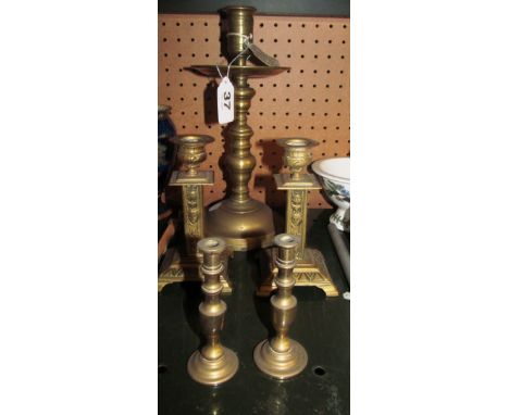 A brass bell metal candlestick converted for electricity, pair of brass candlesticks with embossed mask columns and a pair of