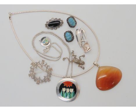 A silver and enamel pendant by silversmith Jane Moore, a silver stylized heron brooch stamped BNY, a thistle brooch by Ortak 