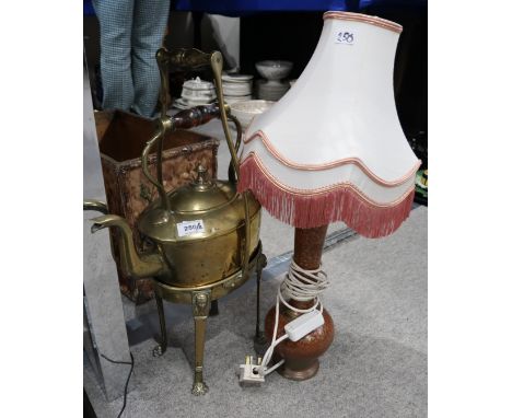 A brass spirit kettle and stand 56cm high, and a modern red ground gilt metal lamp with shade, 59cm high Condition Report: No