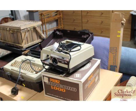 A prinz concorde IQ 1000 projector, together with a Smith Corona portable typewriter and fitted case