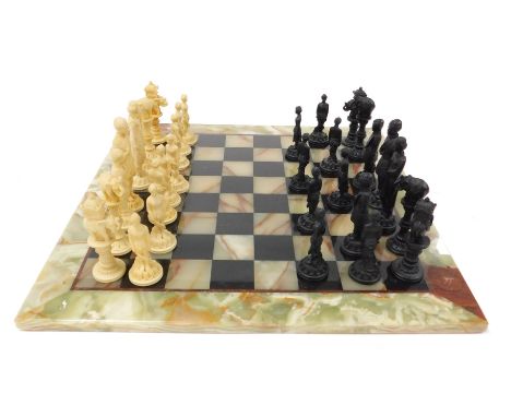 A green onyx and black slate chessboard, with Indian figural resin chess pieces.