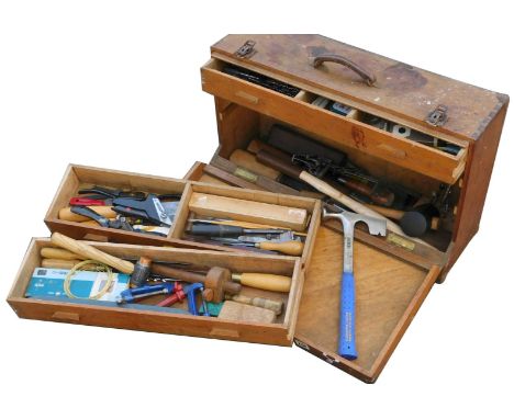 A carpenter's tool chest, the drop front opening to reveal three drawers and a recess, enclosing various tools, 63cm wide.