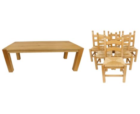A light oak kitchen dining table, raised on stiles, 66.5cm high, 220cm wide, 100cm deep, together with six rush seated ladder