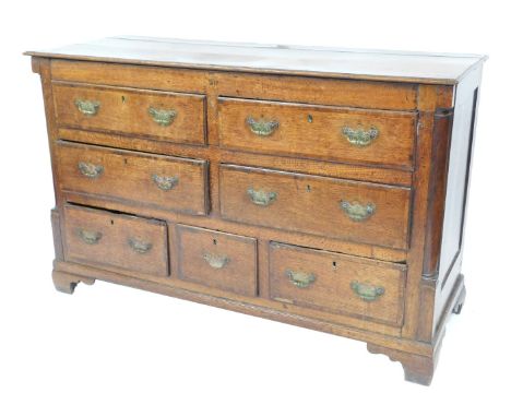 A George III oak and mahogany cross banded Lancashire mule chest, with four long over three short drawers, flanked by quarter