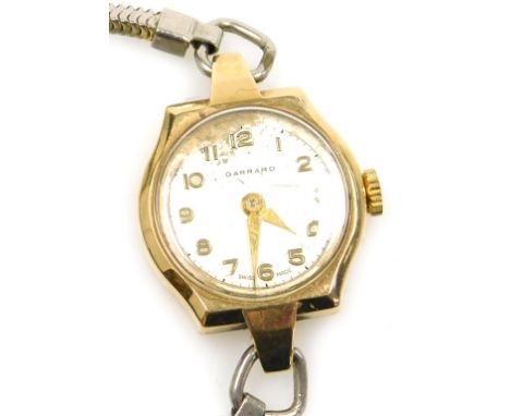 A Garrard lady's 9ct gold cased wristwatch, circular silvered dial bearing Arabic numerals, the case of shaped circular form,