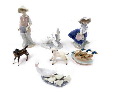 A Lladro porcelain figure of a girl with a basket of flowers, another of a boy, Lladro and Nao groups of ducks and ducklings,