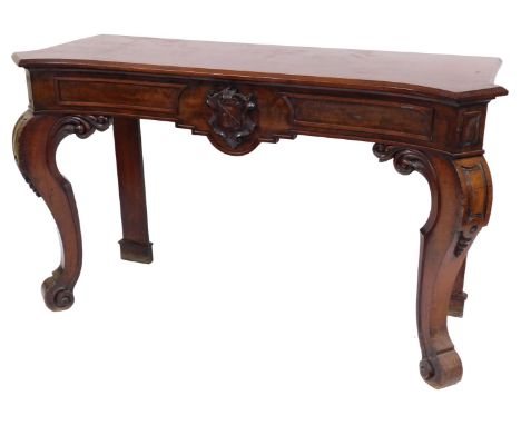 A Victorian mahogany serving table, with a curved top over a frieze with carved coat of arms above a pair of front foliate ca