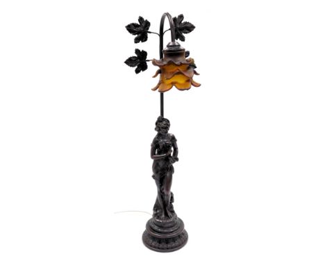 An Art Nouveau style plaster figural table lamp, with a triple layered amber glass floral shade, 69cm high.