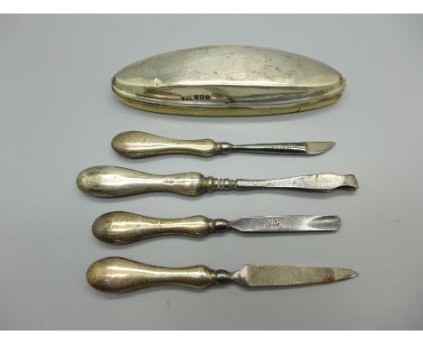 Four silver handled manicure tools and a silver nail buffer 