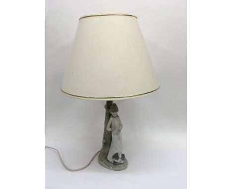 A Nao lamp of a young girl with a terrier type dog.