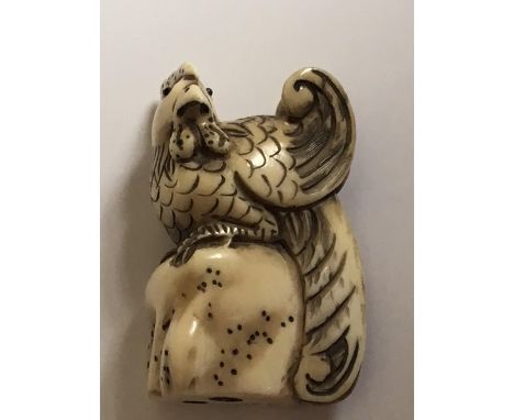 A Japanese carved Ivory Netsuke, of the Meiji period, in the form of a cockrail perched on a rock signed base, 5cm