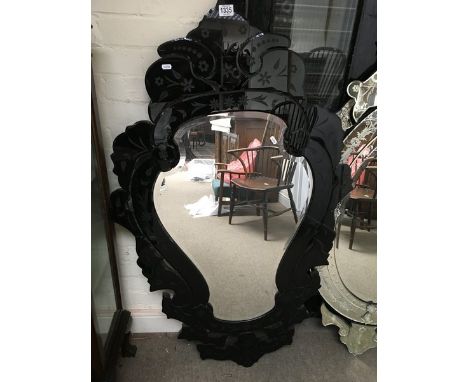A large ornately decorated wall hanging mirror with engraved black surround. Dimensions : height 51 inches, width 31 inches.
