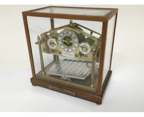 An 8 day Congreve rolling ball mantel clock in a fitted glass case, 22.5cm x 23cm x 14.5cm.