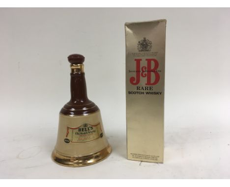 Two bottles of whisky, one being a Bell's old scotch whisky 75cl bottle in a Bell shaped decanter, the other bottle being a b