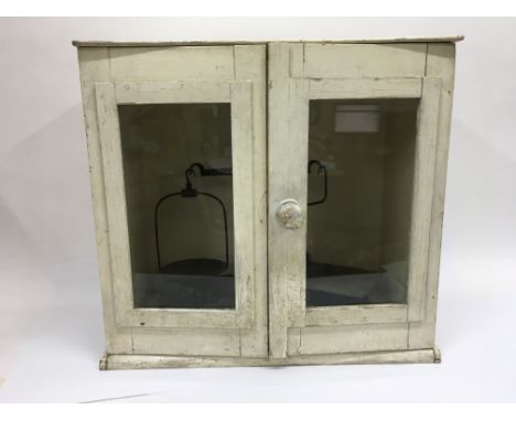 A cabinet containing a set of weighing scales.