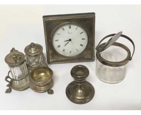 A collection of silver items comprising an Aspery clock, a Victorian silver condiment a small silver rimmed preserve pot and 