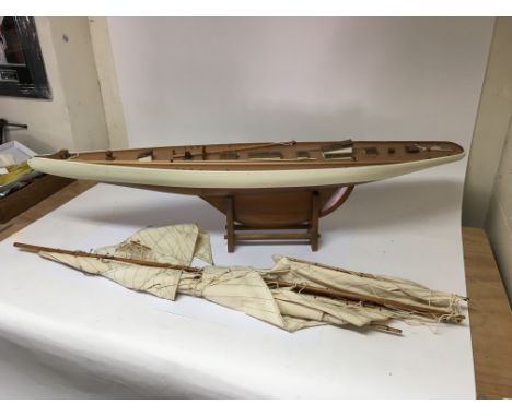 A scratch built model sailing boat complete with a sail and stand. Approximately 123cm long x 24cm deep x 25cm (excluding sai