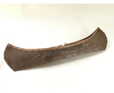 An old handmade North American or Canadian Indian model canoe made from triple bark