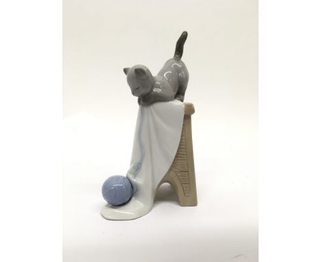 A Nao figurine of a cheeky cat playing with a ball of wool.