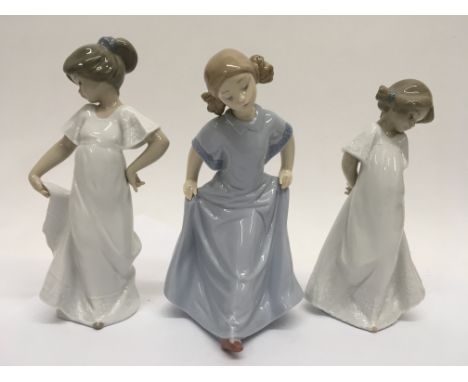 3 Nao figures of young girls in dresses.