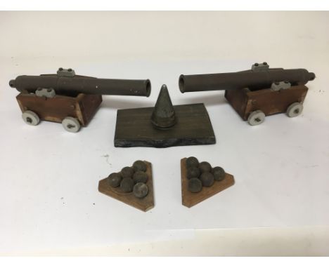 A pair of miniature cannons with cannon balls and related trench art